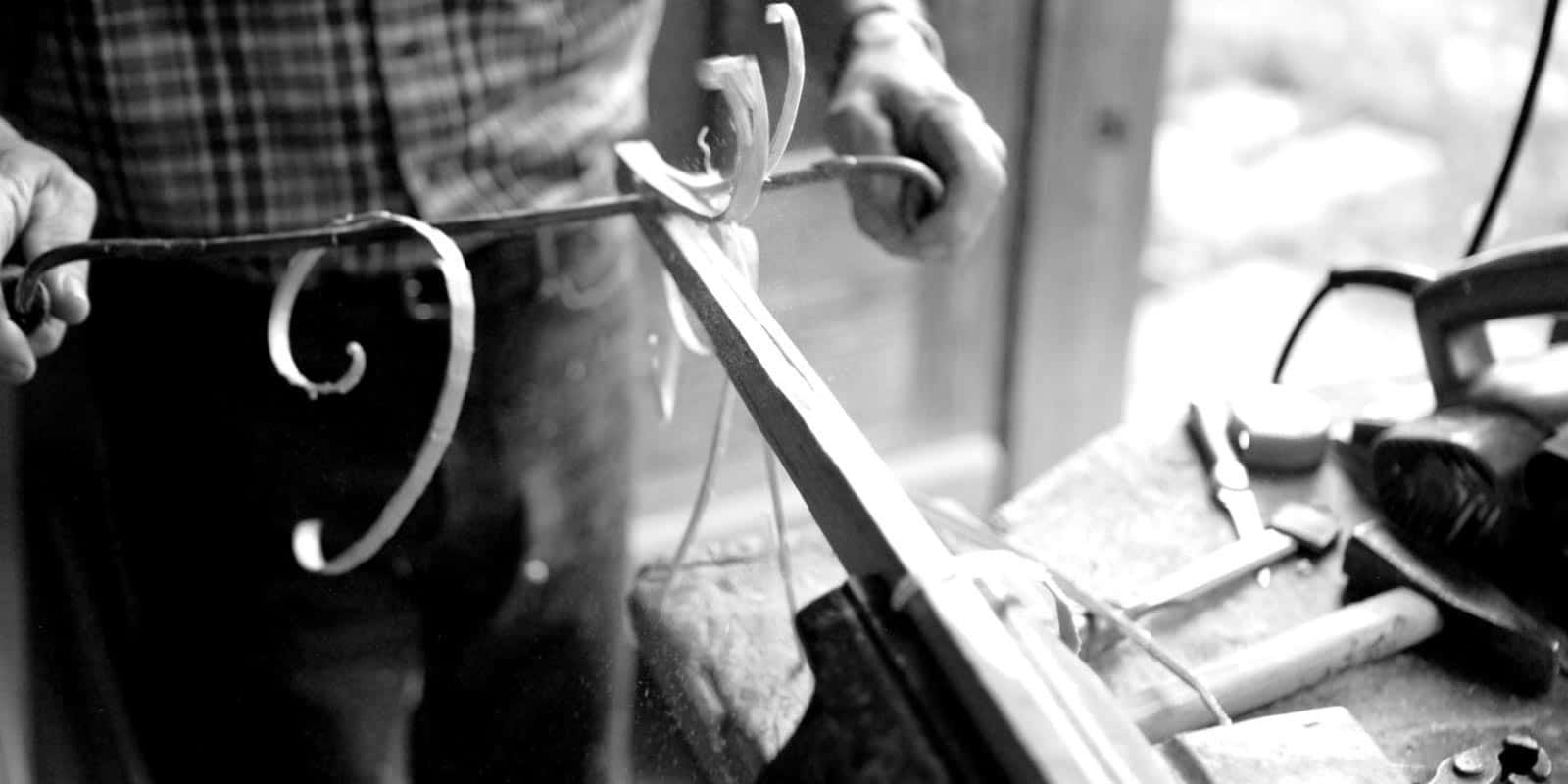 Detail eines Handwerkers bei der Bearbeitung des Holzes