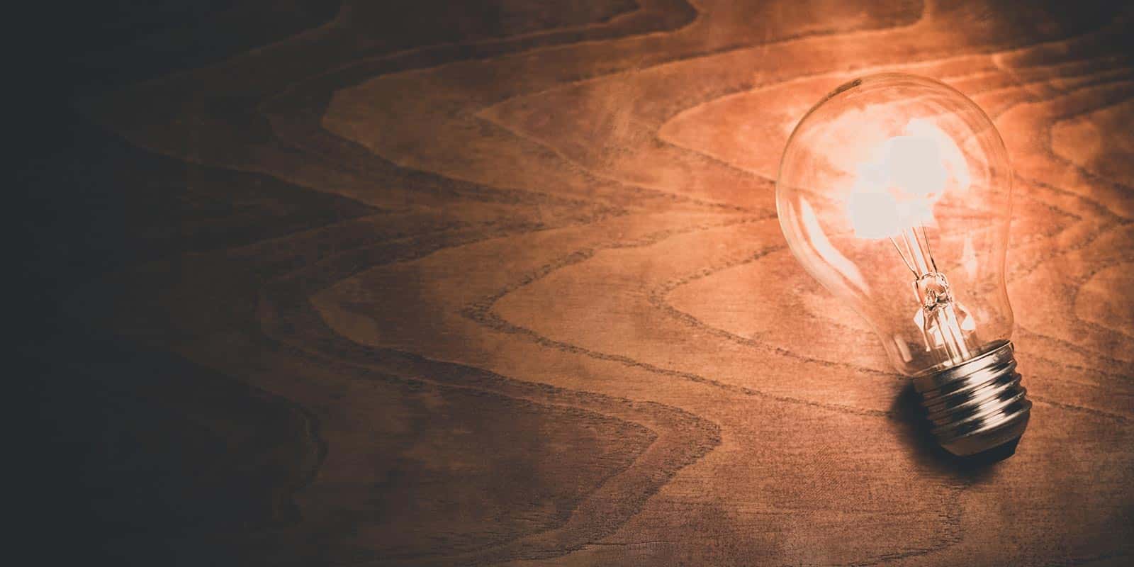 Bild einer Glühbirne, die auf einem Holztisch liegt